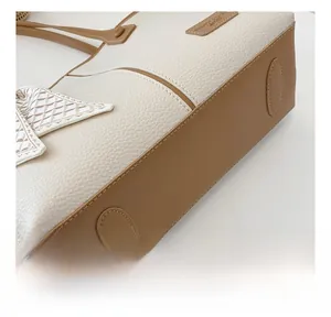 Détail montrant le cuir texturé litchi et les coutures fines sur le sac fourre-tout