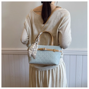 Sac à main bleu avec relief géométrique, poignées en cuir marron et foulard élégant