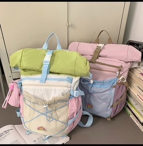Detail of color-block nylon backpacks with front mesh pockets and bungee cord systems