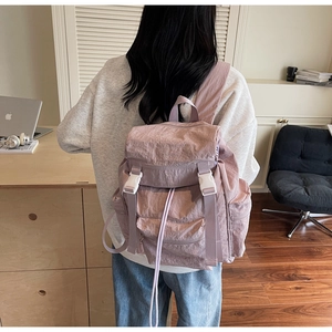 Détail du sac à dos en nylon violet imperméable avec boucles blanches et cordon de serrage
