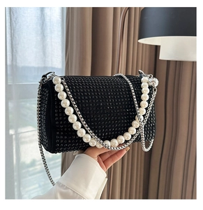 Detail of black rhinestone Boston bag featuring faux pearl handle and silver chain strap