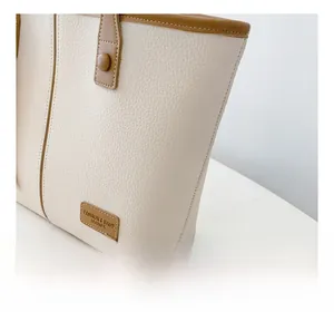 Détail du sac cabas en cuir grainé blanc cassé avec passepoil marron et coutures