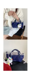 Detail of navy drawstring crossbody bag with white monster plush charm and logo print