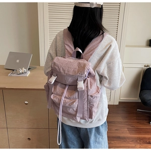 Détail du sac à dos en nylon imperméable avec boucle blanche et bretelles réglables