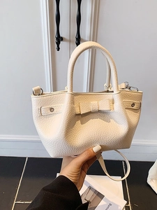 Elegante borsa a secchiello in pelle crema con fiocco decorativo per il pendolare quotidiano