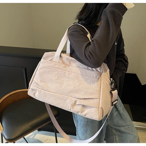 Vue latérale du grand sac de voyage rose en nylon avec bandoulière réglable sur le mannequin
