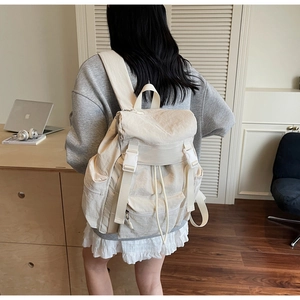Détail du grand sac à dos crème avec fermeture à boucle et bretelles rembourrées