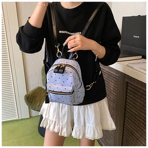 Mini striped backpack with heart prints shown on model to demonstrate compact size