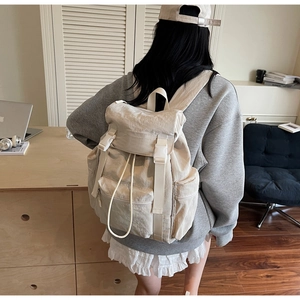 Détail du sac à dos de voyage blanc cassé imperméable avec rabat à deux boucles et cordon