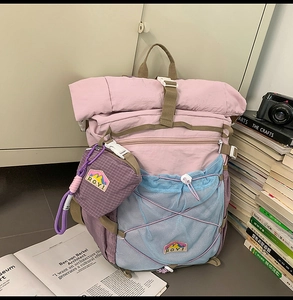 Close-up of pink and purple mesh backpack with RGY patch and mini plaid coin purse detail