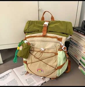 Close-up of color-block nylon backpack with roll-top closure and mesh storage details