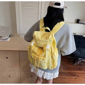 Vue arrière d'un mannequin portant un sac à dos de voyage jaune léger et imperméable