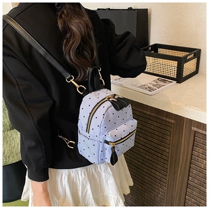 Mini canvas backpack featuring blue stripes, heart print, and faux leather details