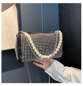 Detail of a black velvet barrel bag with sparkling rhinestones and pearl handle