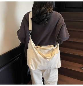 Detaillierte Seitenansicht einer großen weißen Canvas-Tasche mit Seitentaschen und Tragegurten