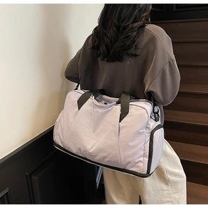Detail of light purple sports bag showing the independent shoe compartment and side pocket