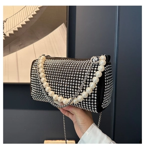 Close-up of luxury Boston bag with sparkling rhinestones and elegant pearl chain handle