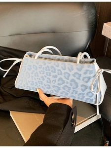 Light blue leopard print shoulder bag with white handles and bow ribbon details