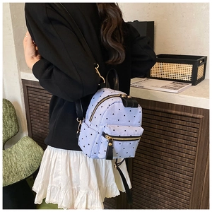 Close-up of heart pattern mini backpack with golden metal zippers and adjustable straps