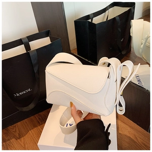 Close-up of white puzzle shoulder bag with lychee texture leather and wide strap