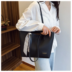 Detail of black lychee grain tote bag featuring a geometric silk scarf and golden lettering