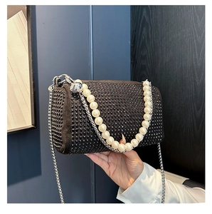 Detail of black Boston bag with sparkling rhinestones, pearl handle, and metal chain