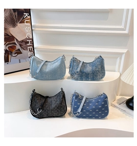 Detail of trendy denim underarm bags with sequins, metal chains, and leather straps
