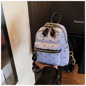 Mini striped canvas backpack with heart pattern and cute bow zipper detail shown in hand