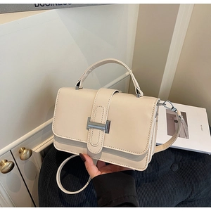 Detail of creamy white crossbody bag with silver metal trim and smooth PU leather texture