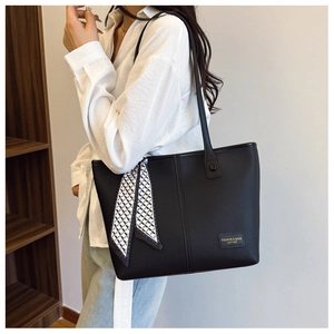 Detail of black lychee grain leather tote bag with stylish geometric silk scarf detail