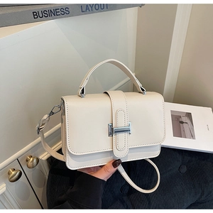 Detail of cream white PU leather handbag featuring a sleek silver rectangular metal clasp