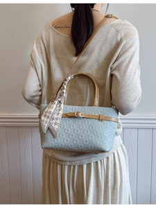 Sac seau bleu clair à motifs géométriques avec poignées brunes et foulard décoratif