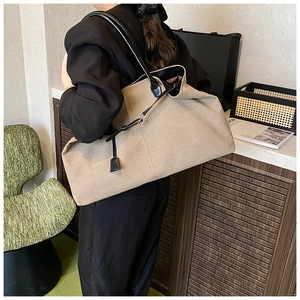 Dettaglio della borsa tote in tela kaki con cinturini in pelle nera e cuciture