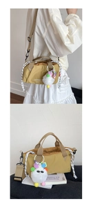 Detail of mustard yellow crossbody bag with drawstring closure and white plush charm