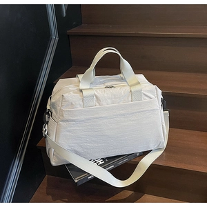 Détail d'un grand sac cabas en toile blanc cassé sur un escalier en bois de style moderne