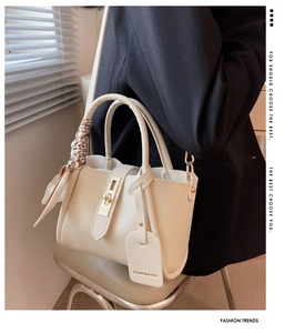 Détail du sac seau en cuir grainé blanc cassé avec fermoir doré et foulard en soie