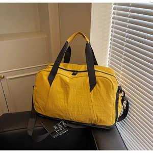 Close-up of a yellow nylon fitness bag on a black chair with natural lighting and shadows