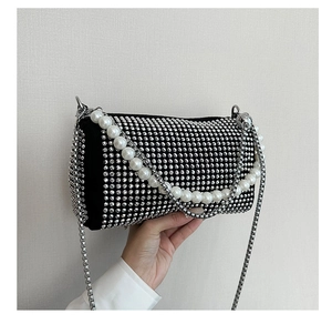 Close-up of sparkling rhinestone grid and pearl chain on a black Boston cylinder bag