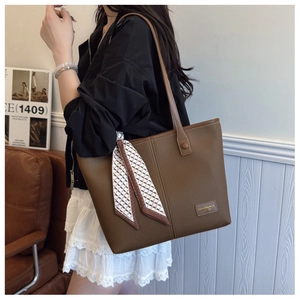 Brown lychee grain leather tote bag with elegant silk scarf detail on the shoulder strap
