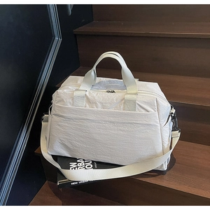 Détail du sac cabas léger en nylon blanc cassé avec de larges anses et une bandoulière