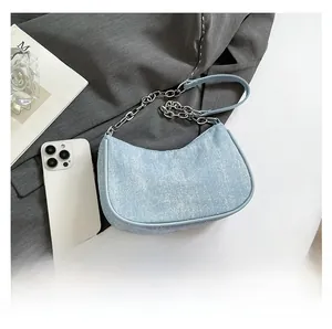 Close-up of light blue denim hobo bag with sparkling rhinestones and silver metal chain
