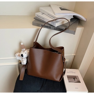 Brown faux leather tote bag with stitch details and a cute puppy plush charm