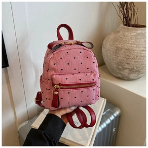 Detailed close-up of a striped mini backpack with red heart patterns and leather bow detail