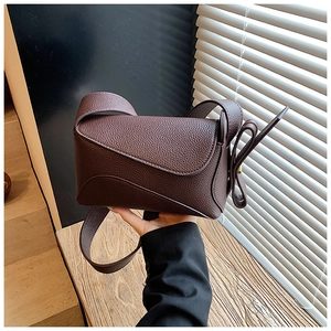 Detailed view of the dark brown lychee leather texture on a modern crossbody bag