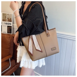 Detail of khaki pebbled leather tote with silk scarf accent and logo metal plate
