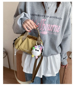 Detail of mustard green canvas bag with C & HONEY CUT text and cute plush charm