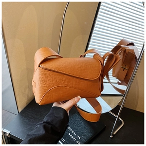 Detail of orange-brown pebble leather handbag with unique geometric flap design