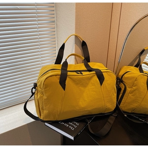 Detail of yellow waterproof nylon gym bag with dry-wet separation and black strap