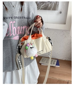 Detail of canvas crossbody bag showing contrast orange lining and cute sheep charm