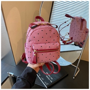 Detail showing mini striped backpack with heart pattern, bow trim and burgundy leather straps
